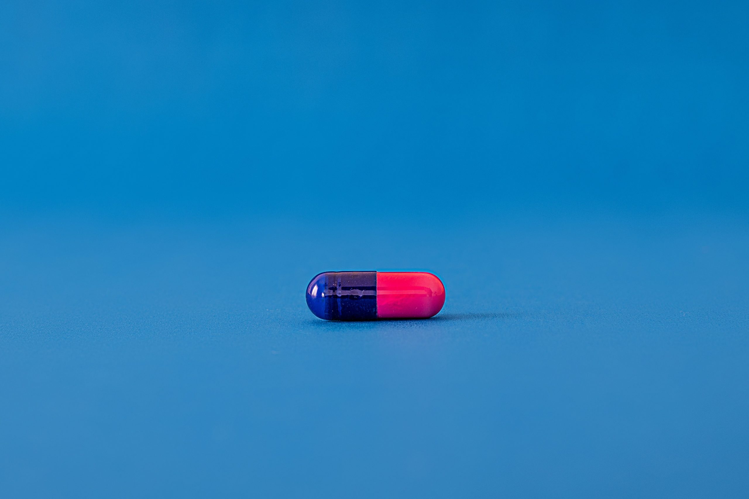 A pink and blue capsule on a blue background