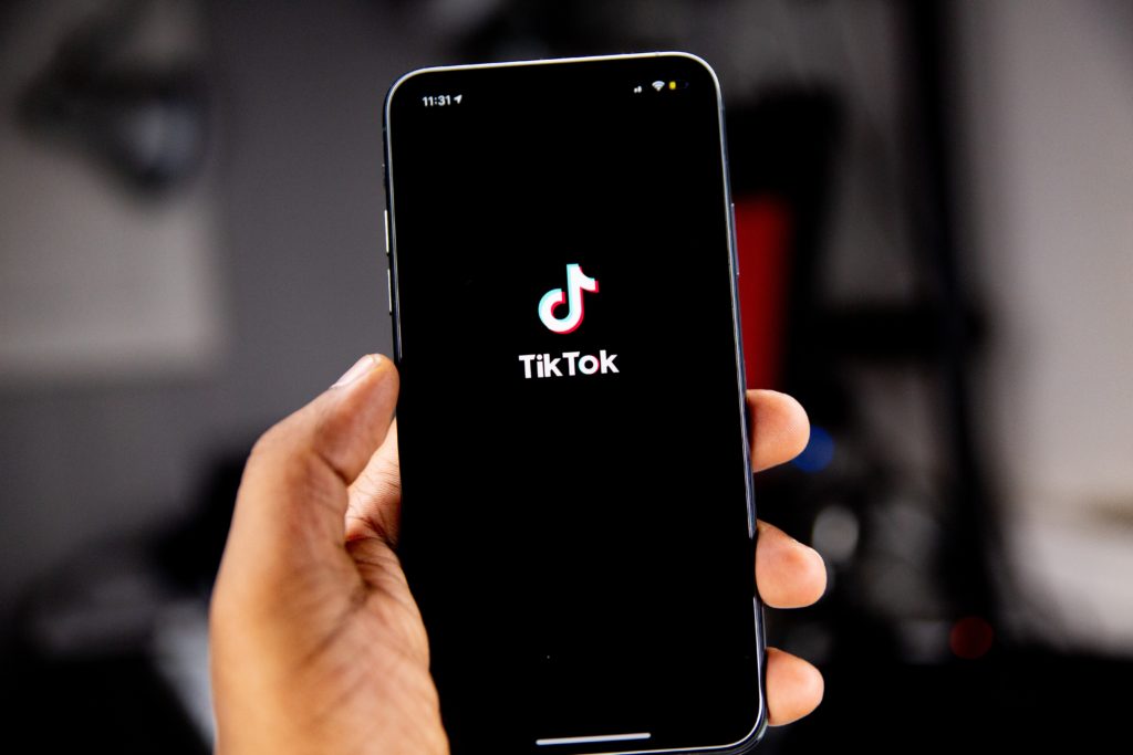 A person holding their cell phone up with the TikTok app opened up.