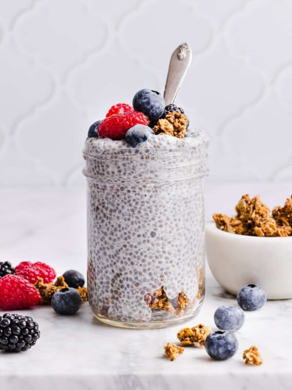 Protein chia pudding topped with berries and granola, in a glass jar
