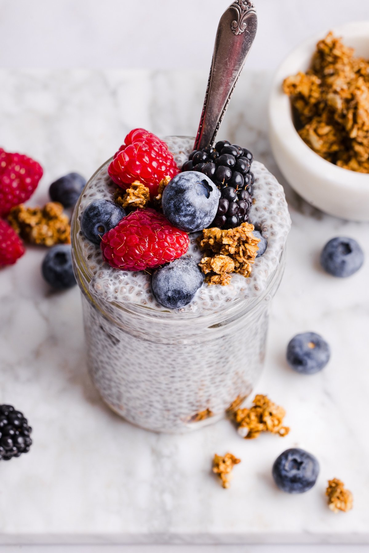 Chia pudding in a glass jar, topped with berries and granola