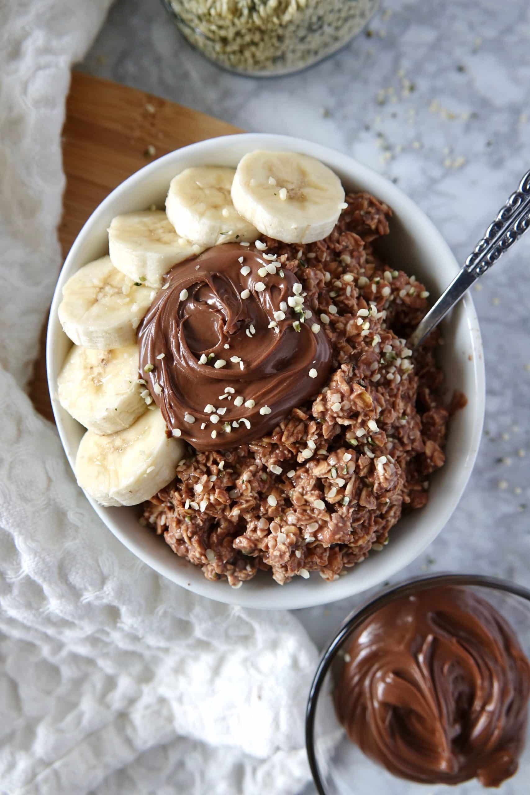 With just 5 minutes of prep, these Nutella overnight oats are the perfect way to start a busy morning. Loaded with protein and fiber! Overhead view of a bowl of Nutella overnight oats topped with extra Nutella and banana slices