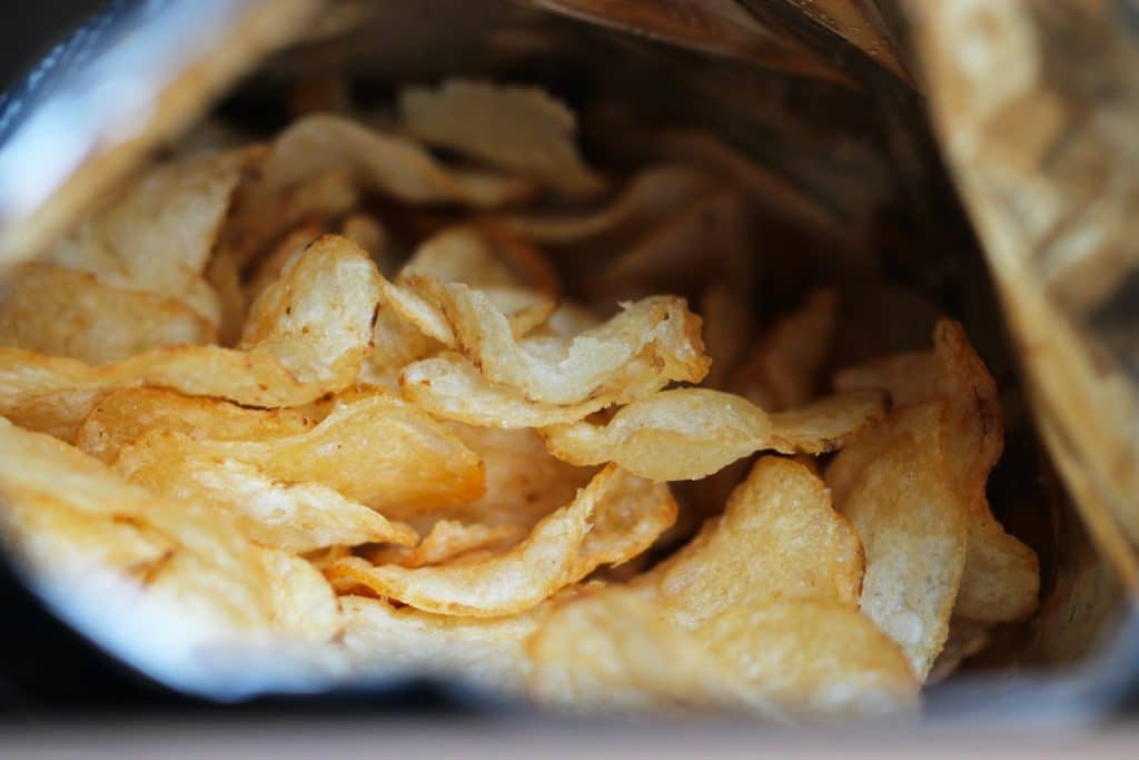 Close-up photo of a bag of potato chips laying open.