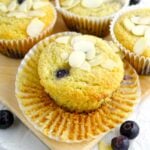 Almond flour blueberry muffins placed on a wood board on parchment paper on the counter.
