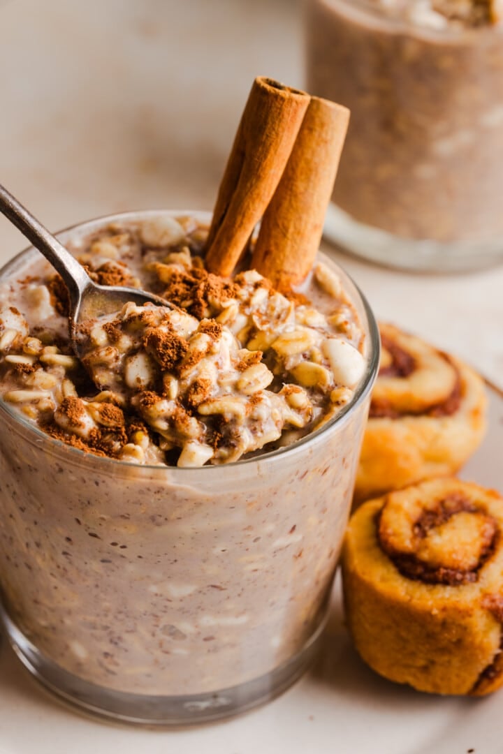 Cinnamon roll overnight oats being spooned from a glass.