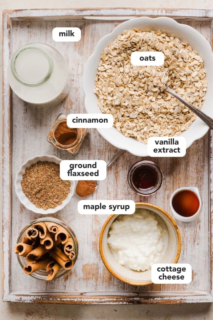 Ingredients for cinnamon roll overnight oats in small bowls on the kitchen counter.
