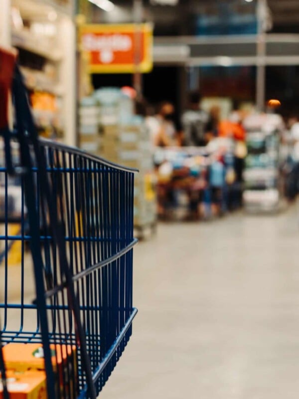 Black grocery cart with blurred background of supermarket.