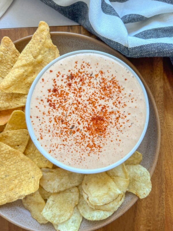 3 Ingredient taco dip made with blende cottage cheese, taco seasoning, and chopped green chillies on a plate with chips