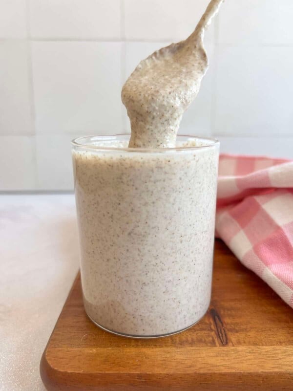 blended oatmeal in a glass jar with a spoon taking a scoop