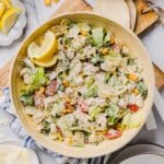Chicken caesar pasta salad tossed in a large bamboo mixing bowl.