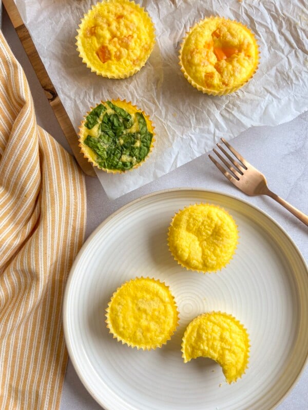 cottage cheese egg bites on a white plate near a yellow striped kitchen towel