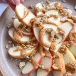 Healthy apple nachos on a plate with peanut butter and granola