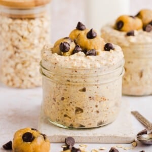 Cookie dough overnight oats with protein in a glass jar, topped with chocolate chips.