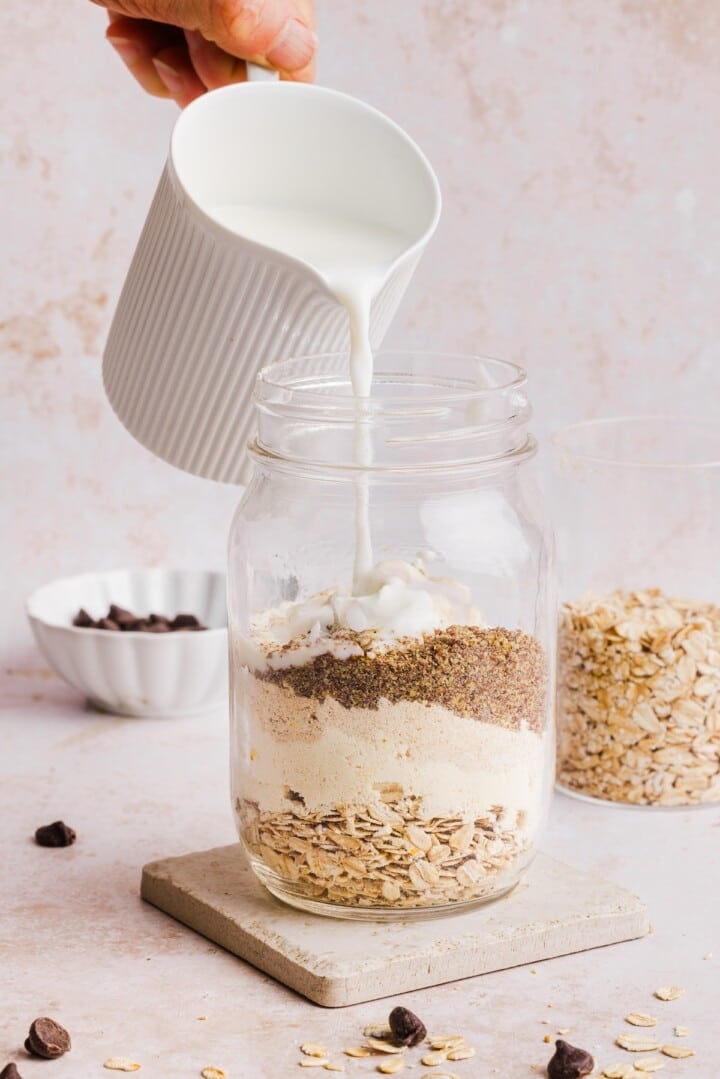 Ingredients for cookie dough overnight oats in a glass jar.