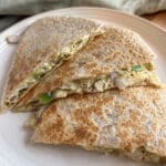 Close-up shot of pesto chicken quesadillas on a plate next to a green kitchen towel