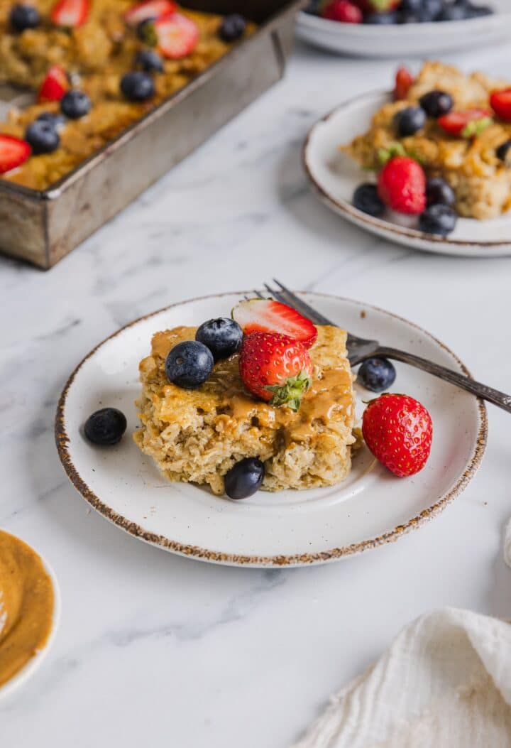 protein baked oatmeal on a white plate with fresh berries.