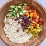 Ingredients for high protein pasta salad in a large wooden salad bowl, unmixed