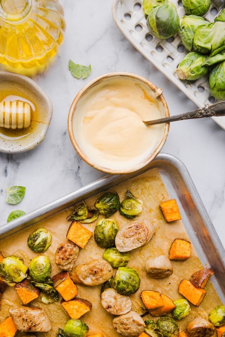 Yogurt honey mustard mixed in a small bowl next to roasted vegetables.