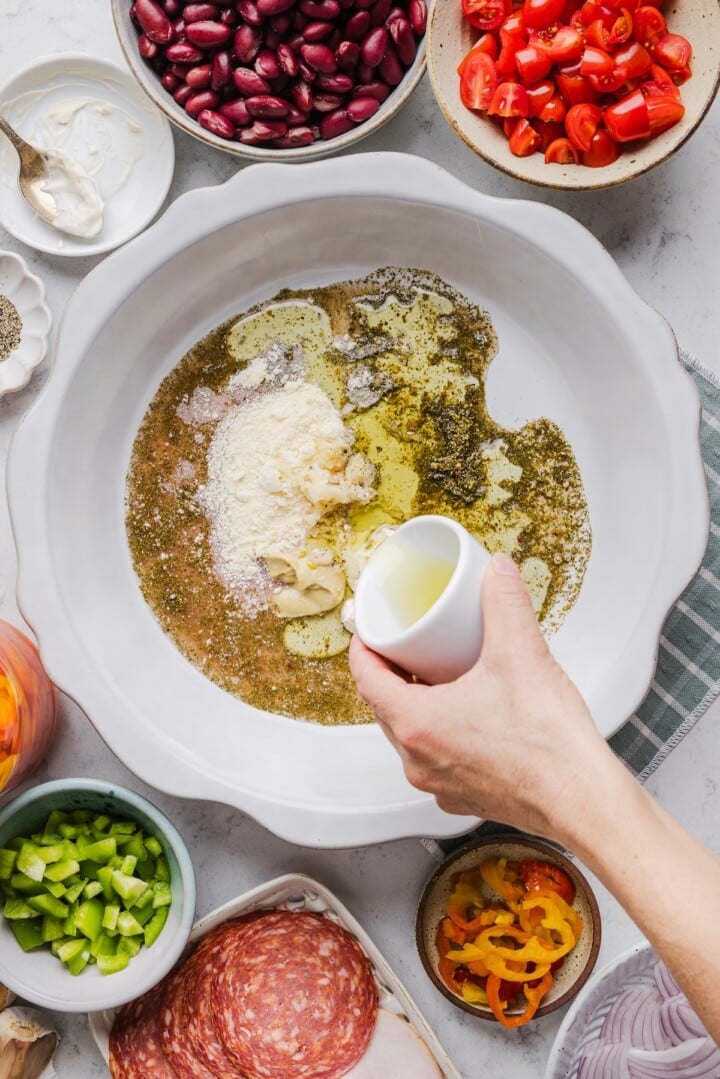 Dressing at the bottom of a large mixing bowl.