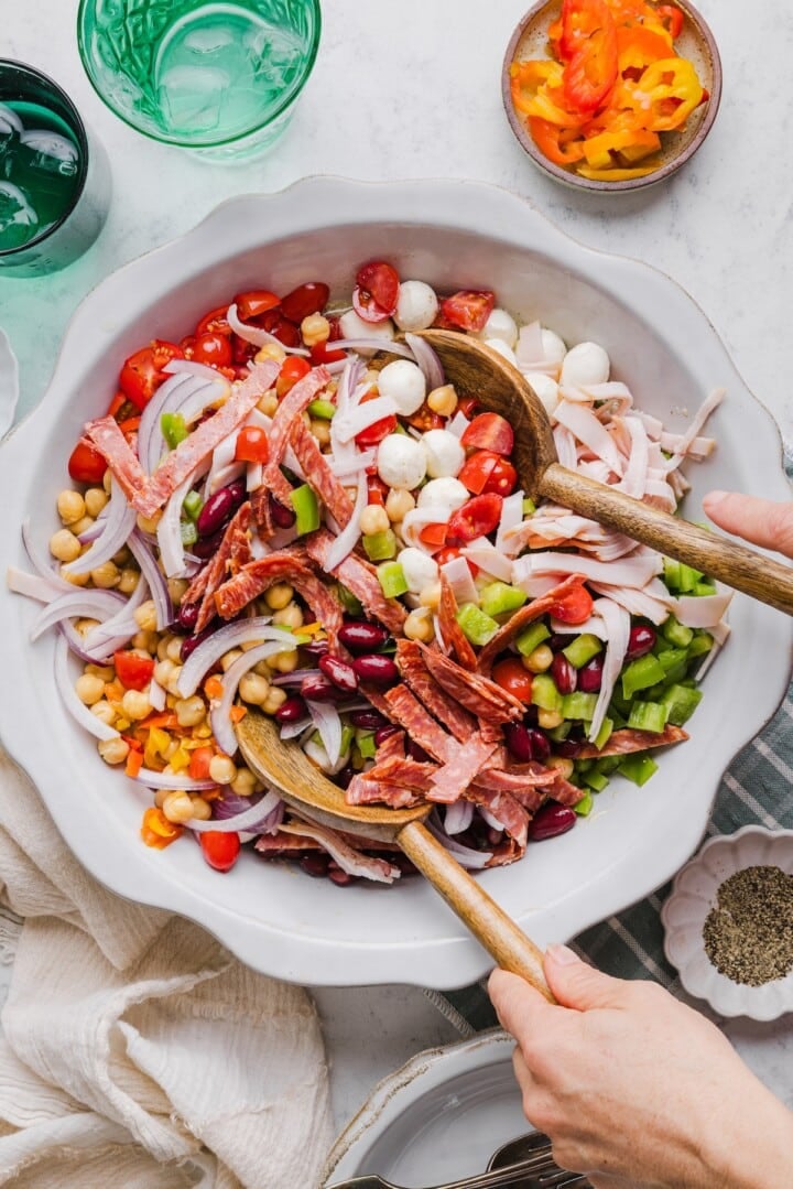 Italian dense bean salad being mixed in a large mixing bowl.
