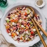 Italian grinder dense bean salad mixed in a large white bowl.
