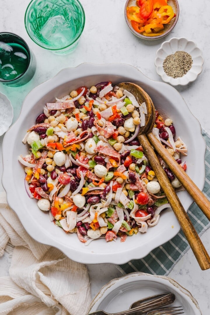 Italian grinder dense bean salad mixed in a large white bowl.