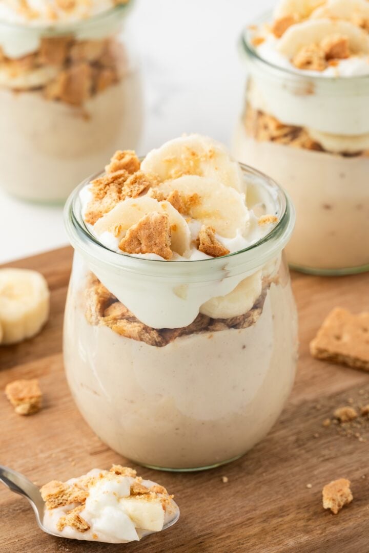 Three jars of protein banana pudding layered in glass jars.