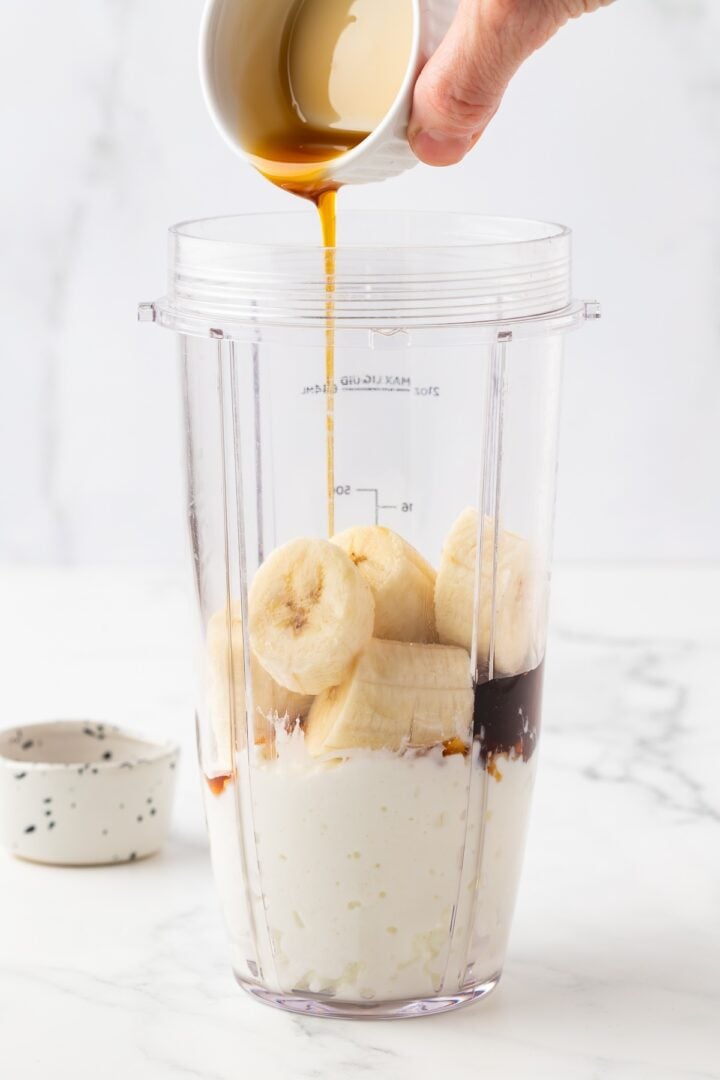 Ingredients for protein banana pudding in a blender cup.