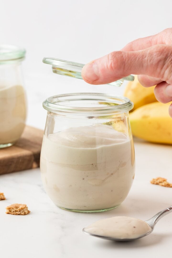 Jar of protein banana pudding being closed with a lid.