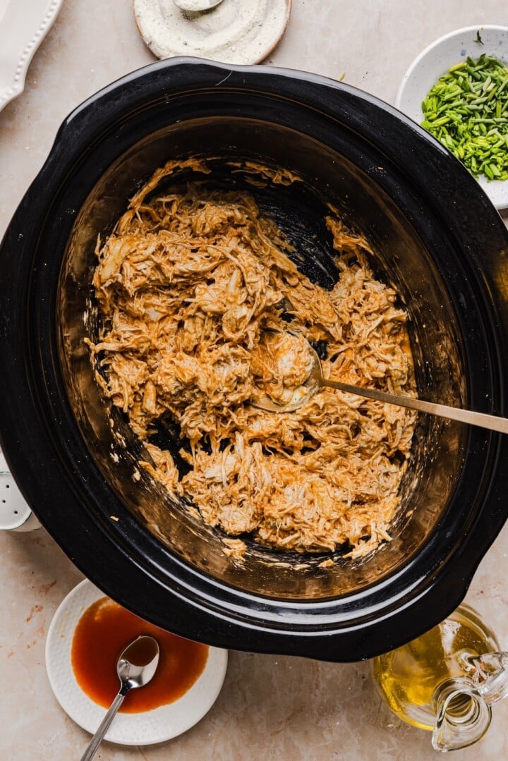 Creamy shredded buffalo chicken for easy weeknight dinner recipe using slow cooker.