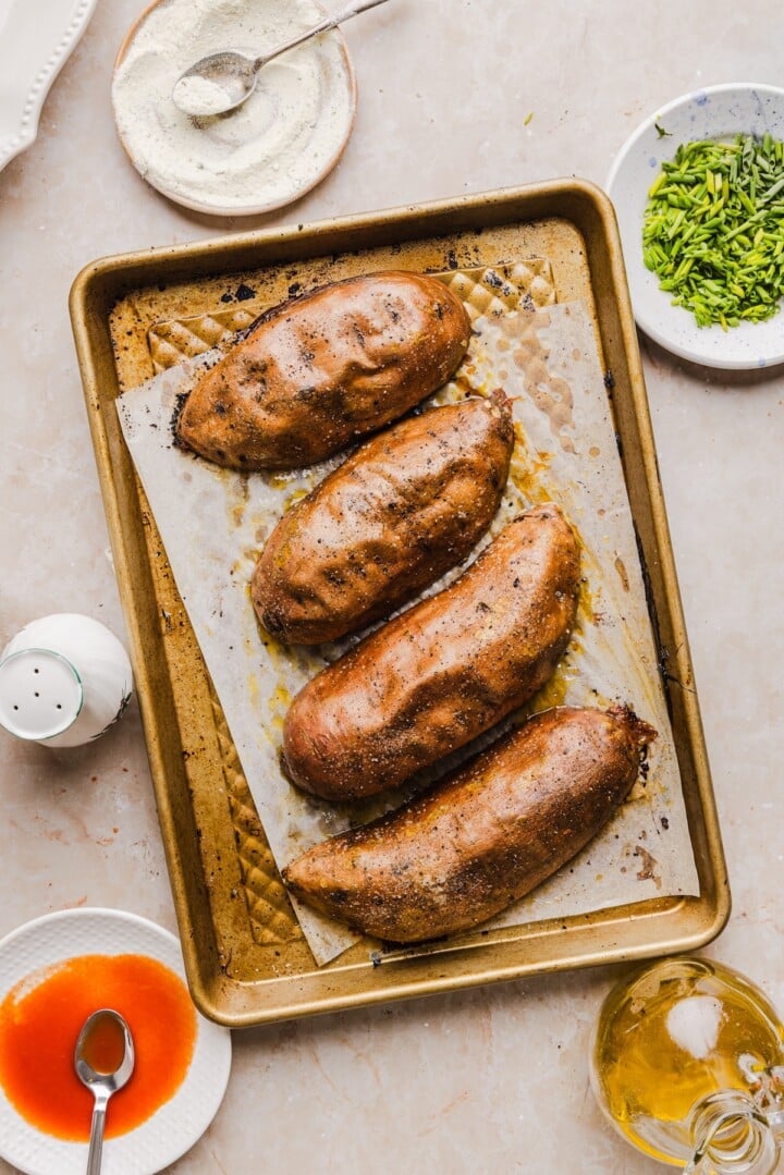 Roasted sweet potato halves on a sheet pan.