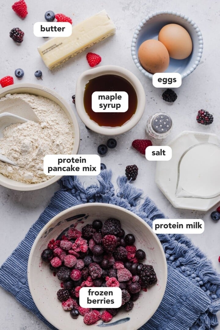 Ingredients for protein pancake muffins displayed in small bowls on a grey marble counter.