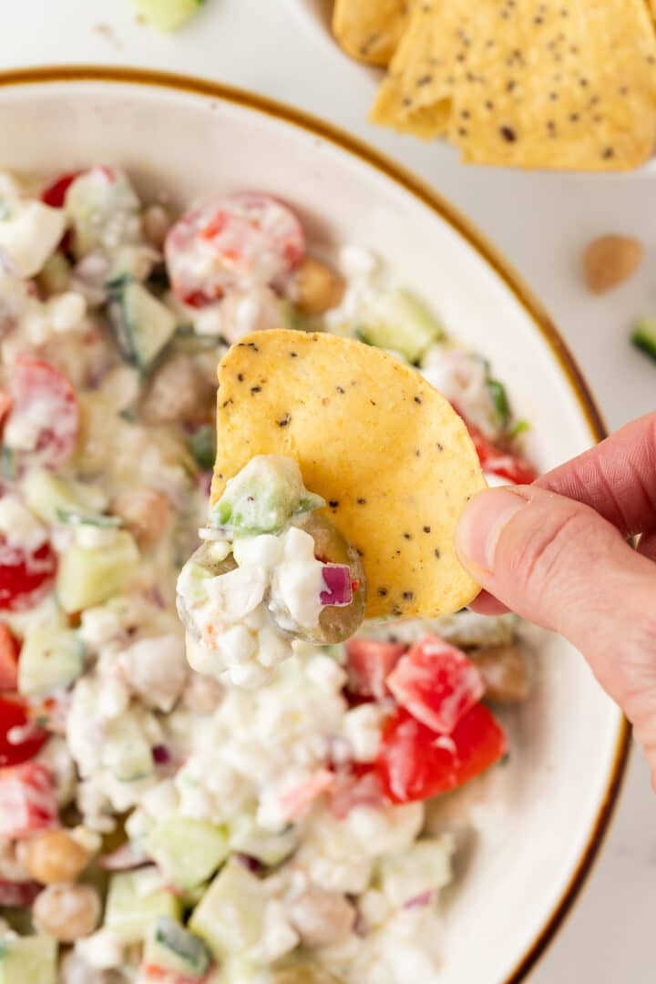 Cottage cheese greek salad scooped onto a tortilla chip.