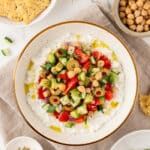 Greek-inspired cottage cheese salad in a bowl next to tortilla chips.