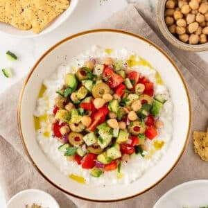 Greek-inspired cottage cheese salad in a bowl next to tortilla chips.