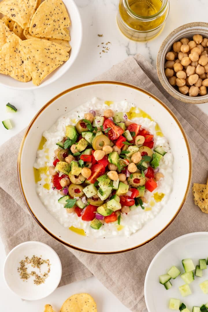 Greek-inspired cottage cheese salad in a bowl next to tortilla chips.