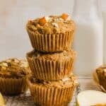 Apple cinnamon oatmeal muffins piled on a cooling rack.