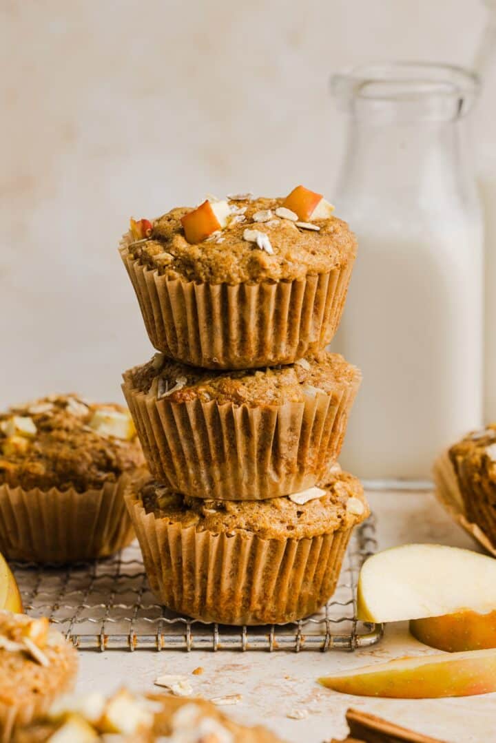 Apple cinnamon oatmeal muffins piled on a cooling rack.