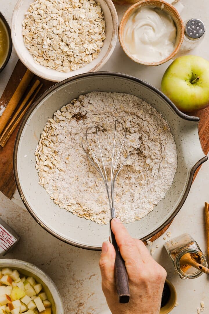 Dry ingredients for apple cinnamon oat muffins in a large mixing bowl.