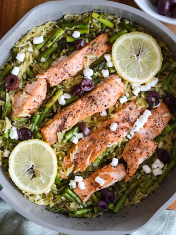 Salmon and orzo recipe with lemon and greek-inspired flavors in a large non-stick skillet
