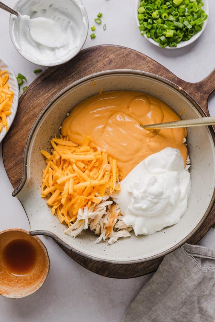 Ingredients for cottage cheese buffalo chicken dip in a large mixing bowl.