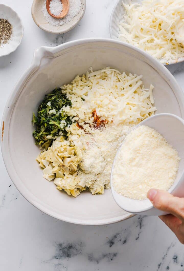Ingredients for healthy spinach artichoke dip in a large white bowl.