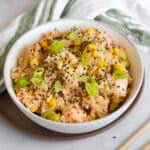 One pot salmon rice bowl made in the rice cooker plated in a white bowl and topped with sesame seeds