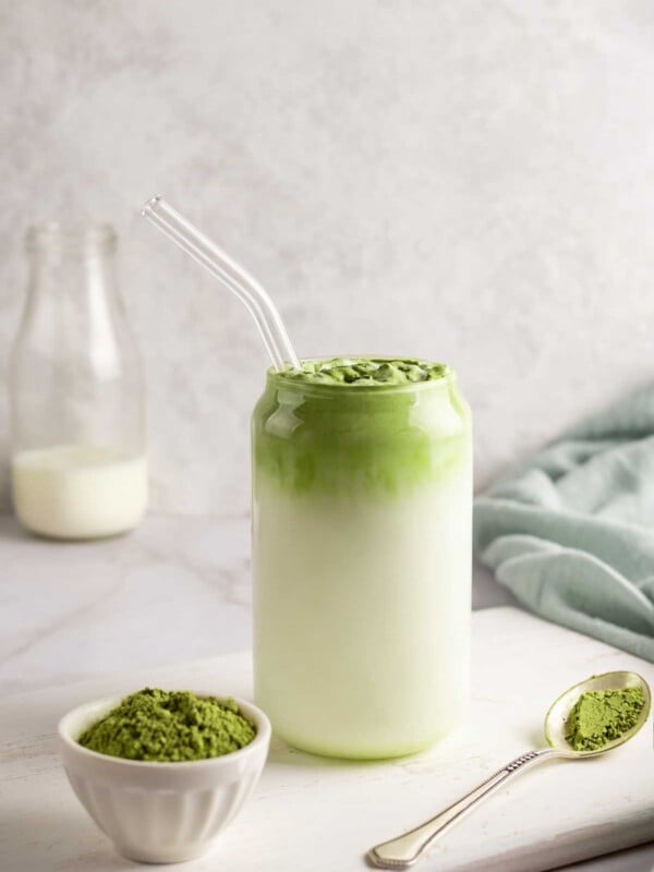 Matcha latte in a glass cup with a glass straw