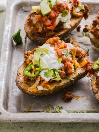 Stuffed taco baked potatoes on a sheet pan.