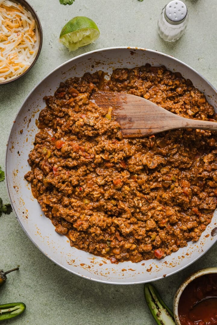 Ground beef taco filling simmering in a large pan.