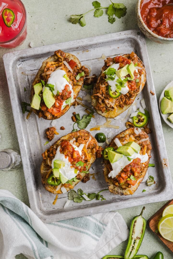 Taco stuffed baked potatoes topped with beef, sour cream, and avocado.