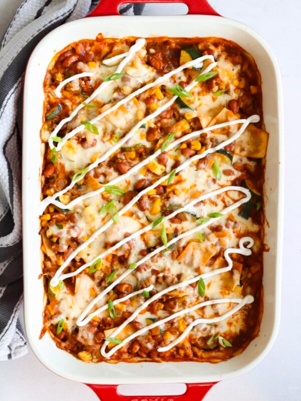 Turkey zucchini enchilada casserole in a 9x13 ceramic baking dish