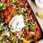 Healthy bell pepper nachos topped with a big dollop of greek yogurt and salsa, on a sheet tray