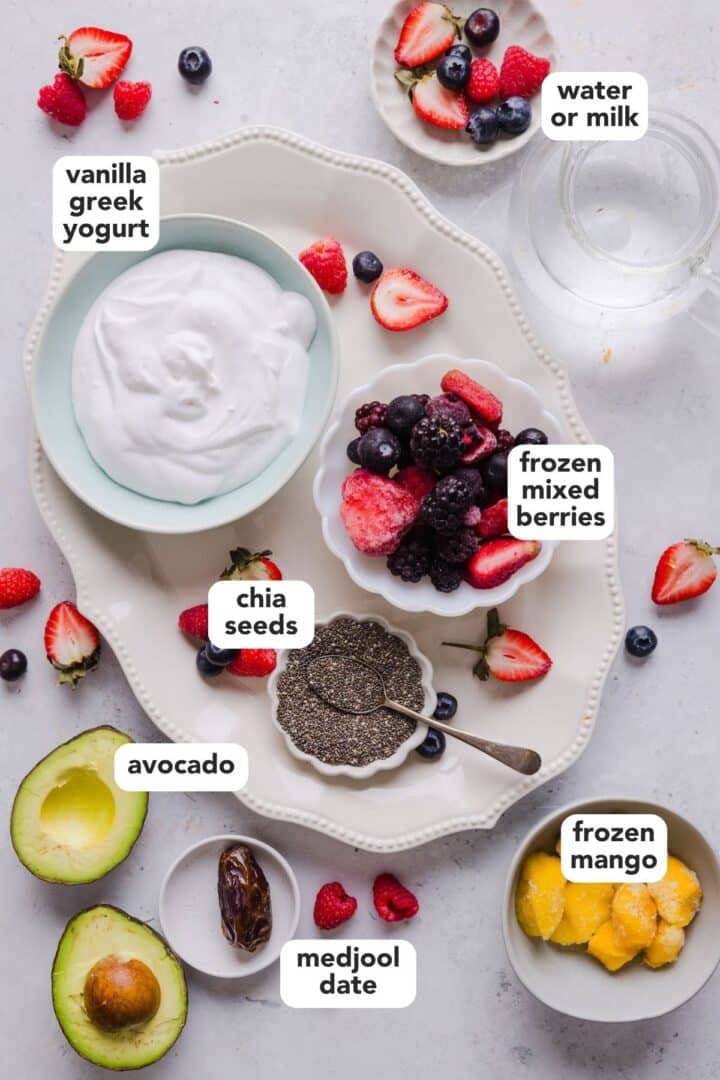 Ingredients for high-fiber smoothie including mixed frozen berries, chia seeds, avocado, vanilla Greek yogurt, frozen mango, and chia seeds.