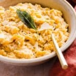 Small white bowl containing cheesy one-pot orzo mac and cheese